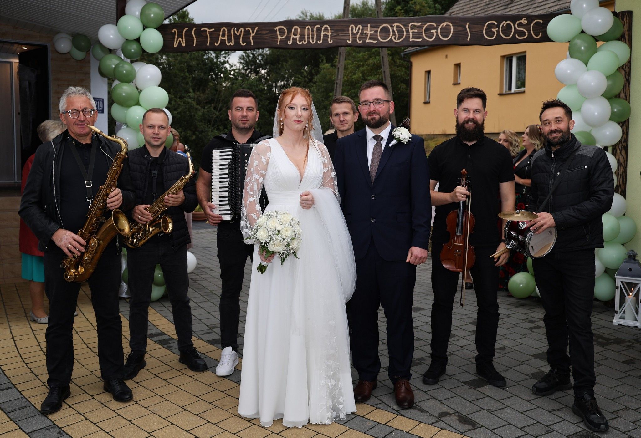 Para Młoda i muzycy OK-EJ Live z instrumentami pod dekoracją z balonów